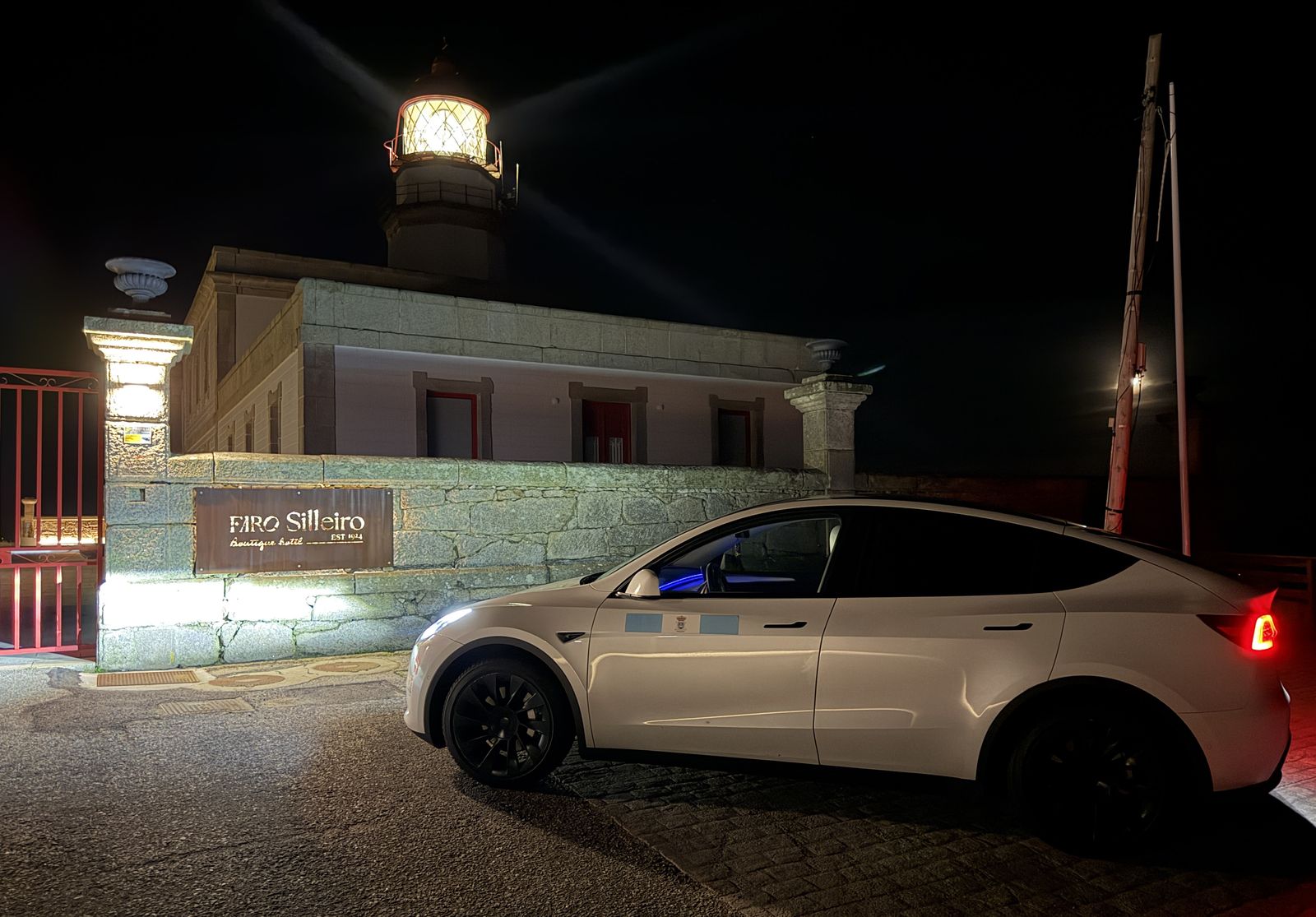 Taxi Tesla Model Y blanco de noche en San Vicente de la Barquera